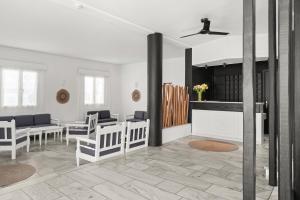 a living room with white furniture and a fireplace at Polos Hotel Paros by GHH in Parikia