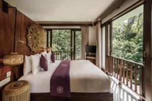 a bedroom with a large bed and a balcony at Dedary Resort & Spa Ubud by Ini Vie Hospitality in Ubud