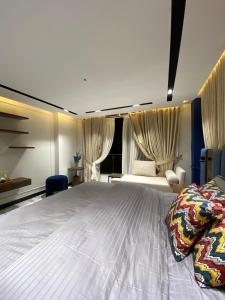 a bedroom with a large white bed with curtains at Sky square murree in Murree
