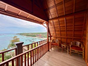a room with a balcony with a view of the water at Prasi Sunrise Sea View in Nusa Penida