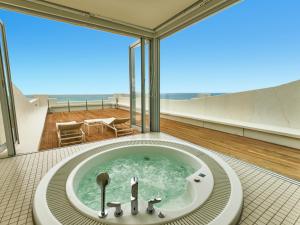 a bathtub in a bathroom with a view of the ocean at Hotel Greges in Munakata