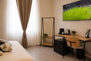 a room with a desk and a tv on the wall at VK Rooms in Bari