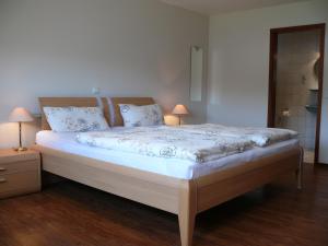 a bed in a room with two nightstands and two lamps at Ferienweingut Wolfgang Adamy in Kinheim