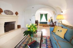 a living room with a blue couch and a fireplace at Masseria San Domenico - Preferred Hotels & Resorts in Savelletri di Fasano