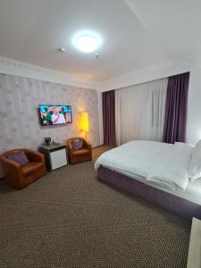 a bedroom with a bed and a tv on the wall at Casa cu pastravi in Sinaia