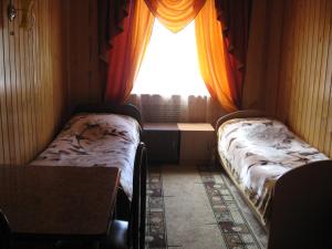 リストヴャンカにあるGuest House Alyanaのベッド2台と窓が備わる小さな客室です。