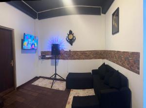 a living room with a couch and a clock on the wall at Eden Heaven Villa in Nuwara Eliya
