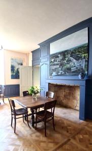 ein Esszimmer mit Tisch und Kamin in der Unterkunft Palais abbatial de Bourgueil in Bourgueil