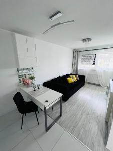 a living room with a black couch and a table at Apartament Borys in Malbork