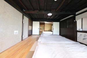 a row of beds are lined up in a room at Entire Traditional House, Pet Friendly,貸切古民家,最大9名,ペット可, 長野岡谷IC5分,ファミリー歓迎 in Okaya