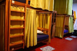 a room with two bunk beds with curtains at Sigiri Serenity Hostel in Sigiriya