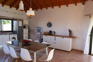a kitchen with a dining table and white cabinets at casa verde in Lajares