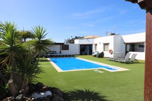 a yard with a swimming pool and a house at casa verde in Lajares