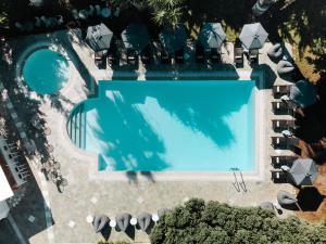 an overhead view of a swimming pool with chaise lounge chairs at Polos Hotel Paros by GHH in Parikia +36 photos