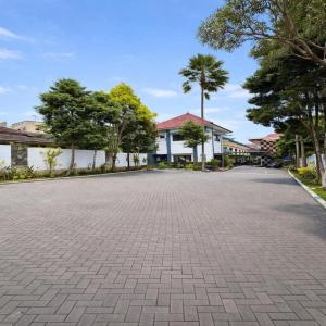 an empty parking lot with trees and a building at Hotel Prima Asri 153 in Batu