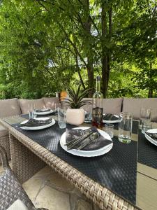 a table with plates and glasses and a bottle of wine at Green District - Riverside Luxury Lodge in Banja Luka +14 photos