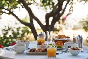 a table topped with breakfast foods and orange juice at Polos Hotel Paros by GHH in Parikia
