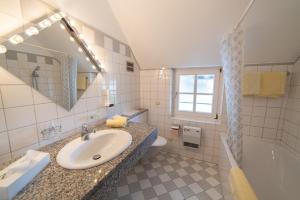 a bathroom with a sink and a toilet and a tub at Hotel Drachenwand-Mondsee in Mondsee +38 photos
