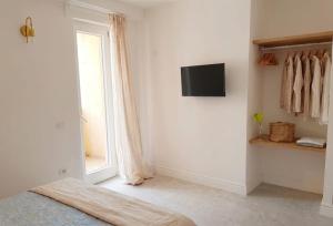 a bedroom with a bed and a window and a television at Enea Dimora Procida in Procida