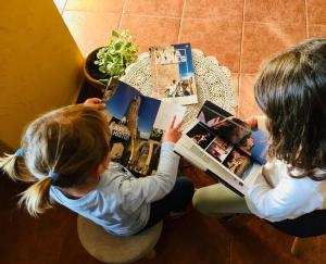 two young girls reading a book on a table at El Portal de Vilafamés in Vilafamés +27 photos