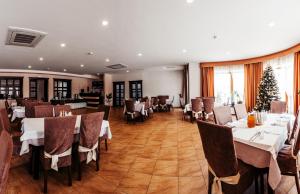 a restaurant with tables and chairs and a christmas tree at Hotel Patriarshyi in Lviv