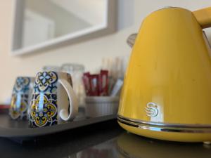 a yellow toaster sitting on a counter next to a mug at Maya's Lodge in Dublin