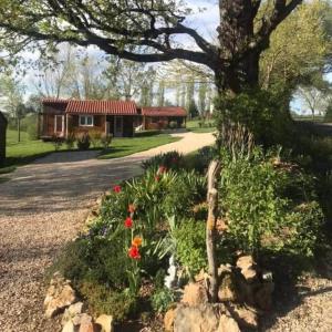 a garden with flowers in front of a house at Chalets du Causse 4 in Gelle