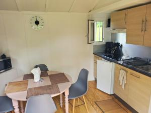 a kitchen with a table and chairs in a kitchen at Chalets du Causse 4 in Gelle