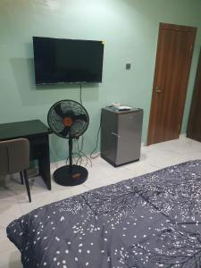 a bedroom with a bed and a desk and a flat screen tv at Torax Lodge in Ibadan +30 photos