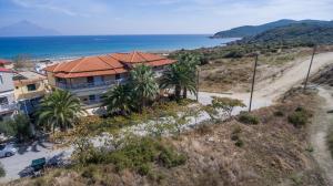 a house on top of a hill next to the ocean at Erifili at Sarti Beach Apartments & Studios in Sarti