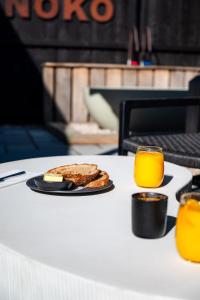 a table with a plate of food and a glass of orange juice at Retreat 10 in Beccles