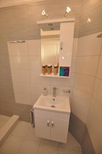 a bathroom with a white sink and a mirror at Ammos in Roda +44 photos