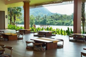 a restaurant with tables and chairs and a view of a lake at Flamingo Tan Trao Resort Managed by Flamingo Hotels & Resorts in Sơn Dương