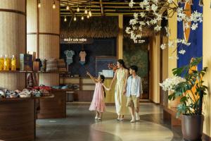 a woman and two children walking through a shopping mall at Flamingo Tan Trao Resort Managed by Flamingo Hotels & Resorts in Sơn Dương +172 photos