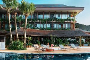 people sitting on chairs in front of a hotel at Flamingo Tan Trao Resort Managed by Flamingo Hotels & Resorts in Sơn Dương