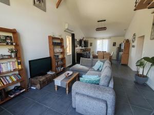 a living room with a couch and a tv at Atelier47 - 7 personnes - proche centre ville - au calme in Marmande