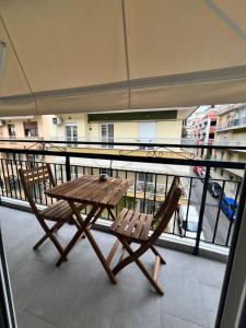 a wooden table and a chair on a balcony at Drama Homes Argiroudi in Drama