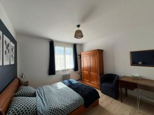 a bedroom with a bed and a desk and a television at Atelier47 - 7 personnes - proche centre ville - au calme in Marmande