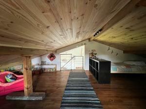 a room with a large wooden ceiling with a pink couch at Atelier47 - 7 personnes - proche centre ville - au calme in Marmande