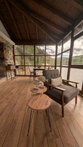 a living room with a couch and tables and windows at Casa rural Mirador, Balneario Histórico de Cortegada in Cortegada