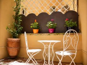 two chairs and a table and some potted plants at Dimora storica - Palazzo Barabesi in Siena