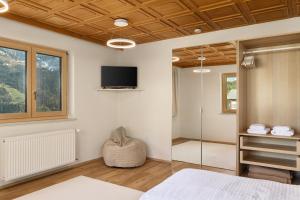 a bedroom with a tv on the wall and a window at Grundwert Apartment in Sonntag