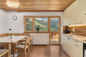 a kitchen with a table and chairs and a window at Grundwert Apartment in Sonntag
