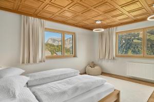 a bedroom with two beds and two windows at Grundwert Apartment in Sonntag