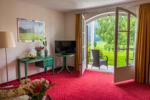 a room with a desk and a sliding glass door at Hotel Drachenwand-Mondsee in Mondsee