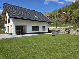 a small white house with a lawn in front of it at Malowany Las in Międzybrodzie Bialskie