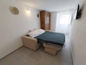 a small bedroom with a bed and a couch at Santanna106 in Santa Domenica