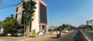 a man riding a bike down a street next to a building at Sky Light Mysore in Mysore South