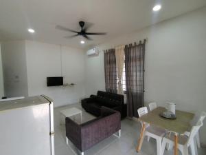 a living room with a black couch and a table at Promenade Homestay 2 in Kampong Sura Masjid