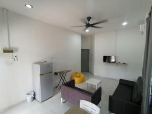 a living room with a couch and a ceiling fan at Promenade Homestay 2 in Kampong Sura Masjid